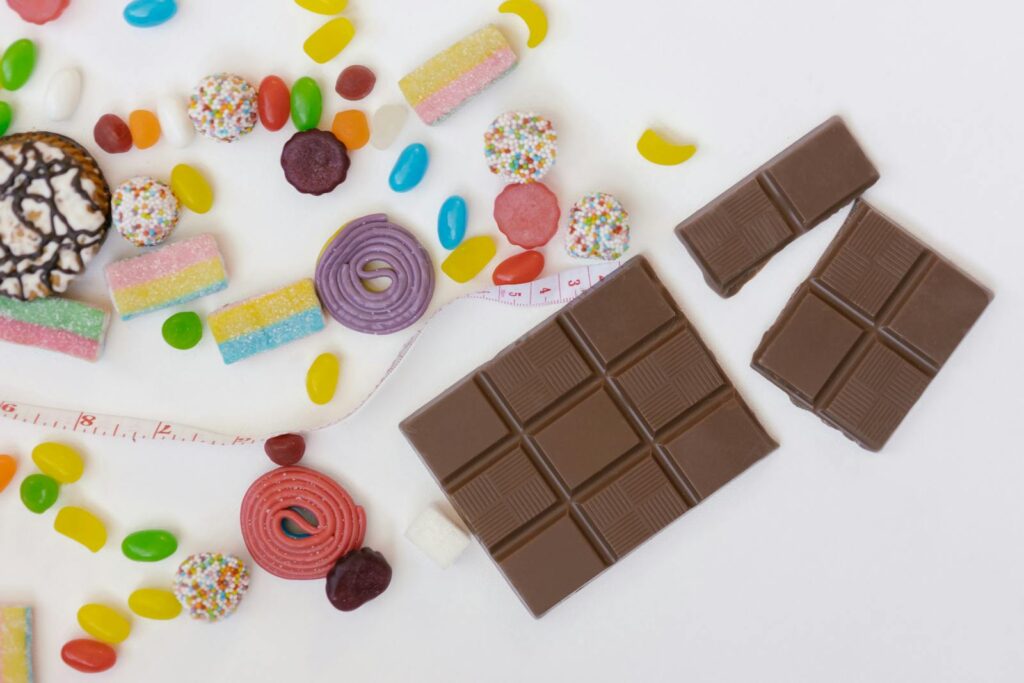 Colorful assortment of candies, chocolates, and sweets on a white surface, perfect for desserts and treats.